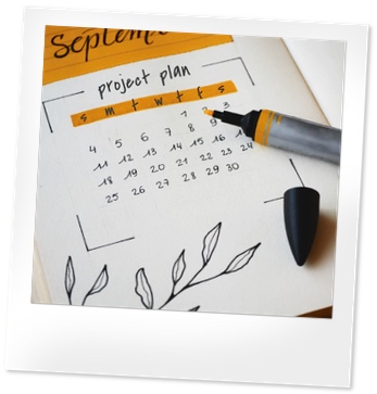 Open page of a project planner with a month laid out and an orange marker.