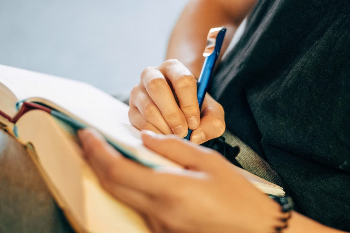 Person writing in a notebook.