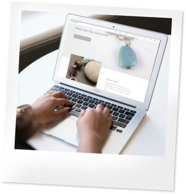 Black person types on a laptop. A website is on the screen.